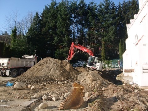 Truck, pile of dirt, and an excavator