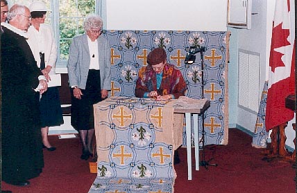 Queen Margrethe sews three stitches in gold.